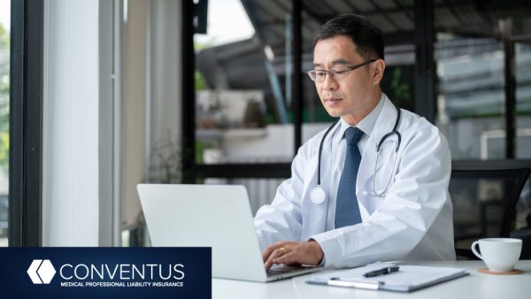 Middle aged doctor at laptop computer